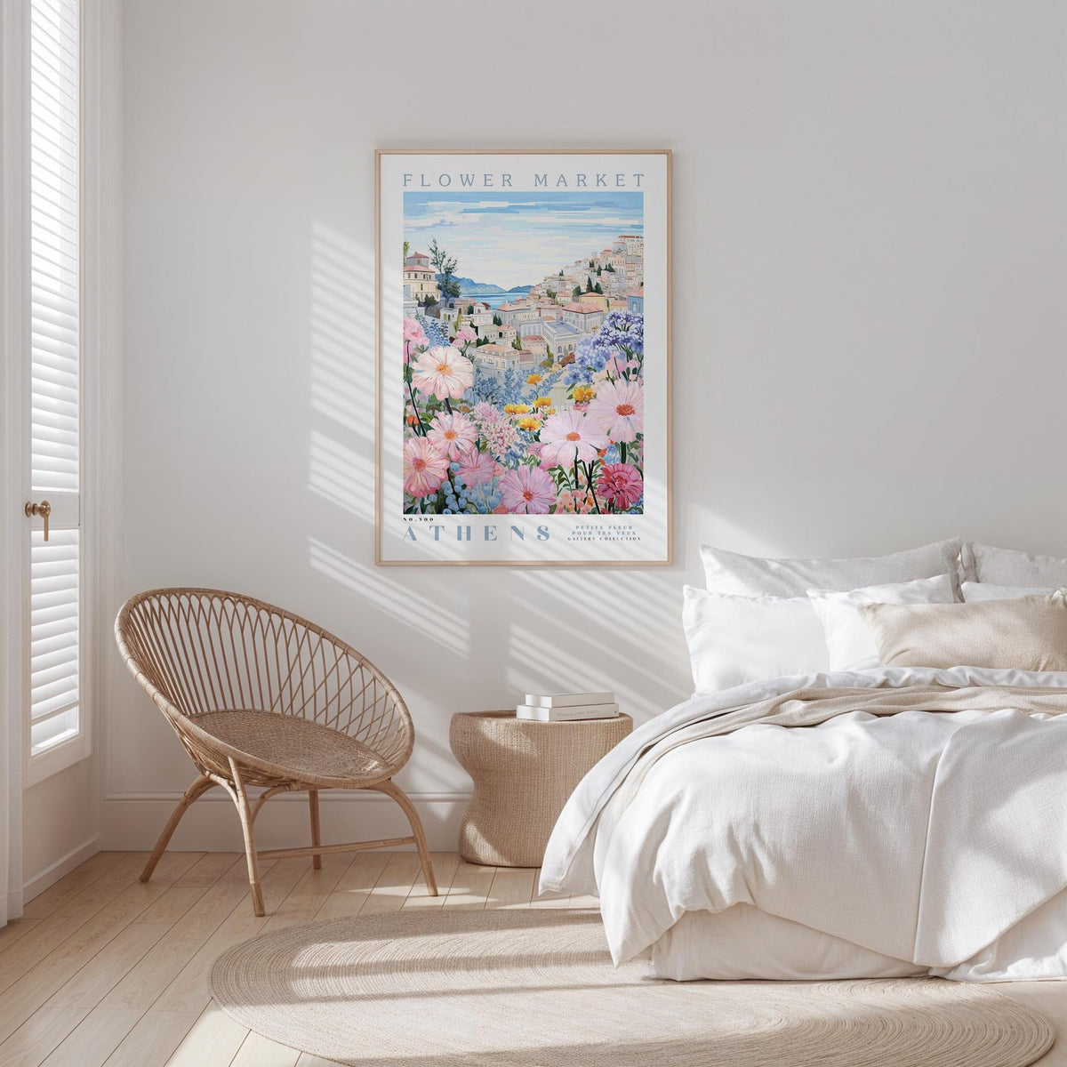 a bedroom with a bed, a woven chair, and a framed poster of a flower market in Athens hanging on the wall.