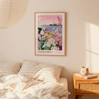 a bedroom scene with a framed poster of a colorful garden hanging on the wall above a bed with striped pillows.