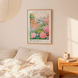 a bedroom with a bed, a nightstand, and a framed poster of a flower market hanging on the wall.