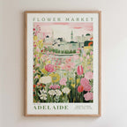 The image is a framed poster depicting a cityscape with a flower market in the background.