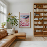 a cozy living room with a large window, a comfortable leather sofa, a wooden bookshelf filled with books, and a framed poster of a floral landscape hanging on the wall.