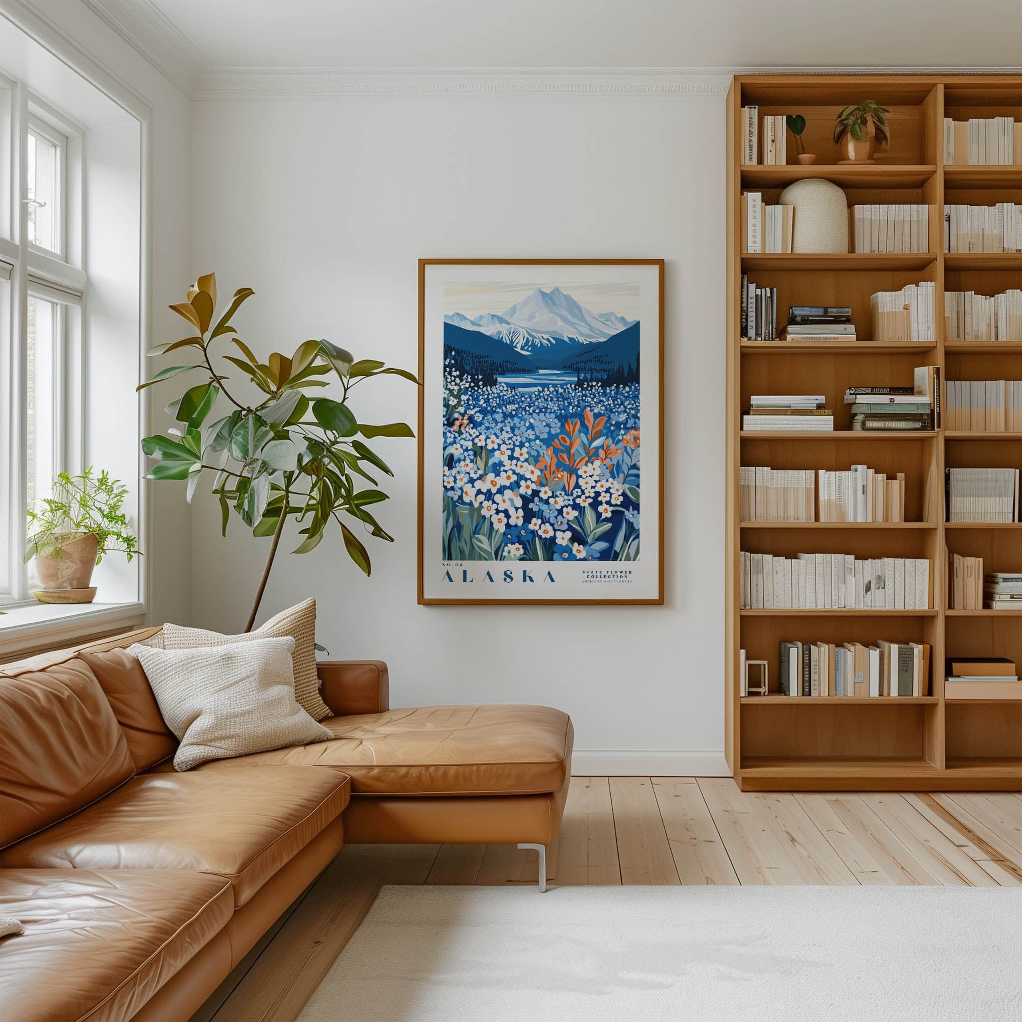a cozy living room with a large window, a comfortable leather sofa, a wooden bookshelf filled with books, and a framed poster of a mountain landscape hanging on the wall.