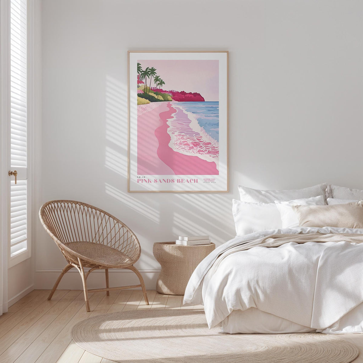 a serene bedroom scene with a large bed, a woven chair, and a framed poster of a beach with palm trees and pink sand.