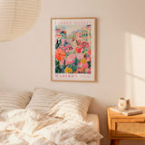 a bedroom scene with a framed poster of a colorful floral scene hanging on the wall above a bed with striped pillows.