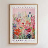 The image is a framed poster depicting a cityscape with a colorful floral field in the foreground.