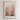 The image is a framed poster depicting a cityscape with a colorful floral field in the foreground.