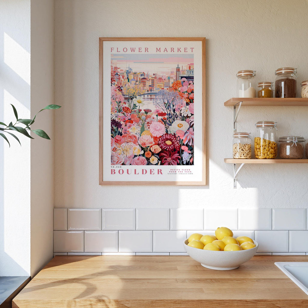 a kitchen scene with a framed poster of a colorful floral scene hanging on the wall above a wooden countertop with a bowl of lemons.