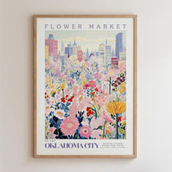 The image is a framed poster depicting a vibrant and colorful cityscape with a variety of flowers and plants in the foreground.
