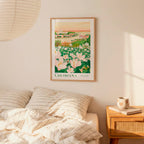 a framed poster of a floral landscape hanging on a wall above a bed with striped pillows.