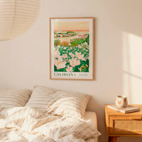 a framed poster of a floral landscape hanging on a wall above a bed with striped pillows.