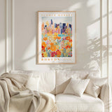 a framed poster of a cityscape with a flower market in the background, hanging on a wall above a white couch with a blanket draped over it.