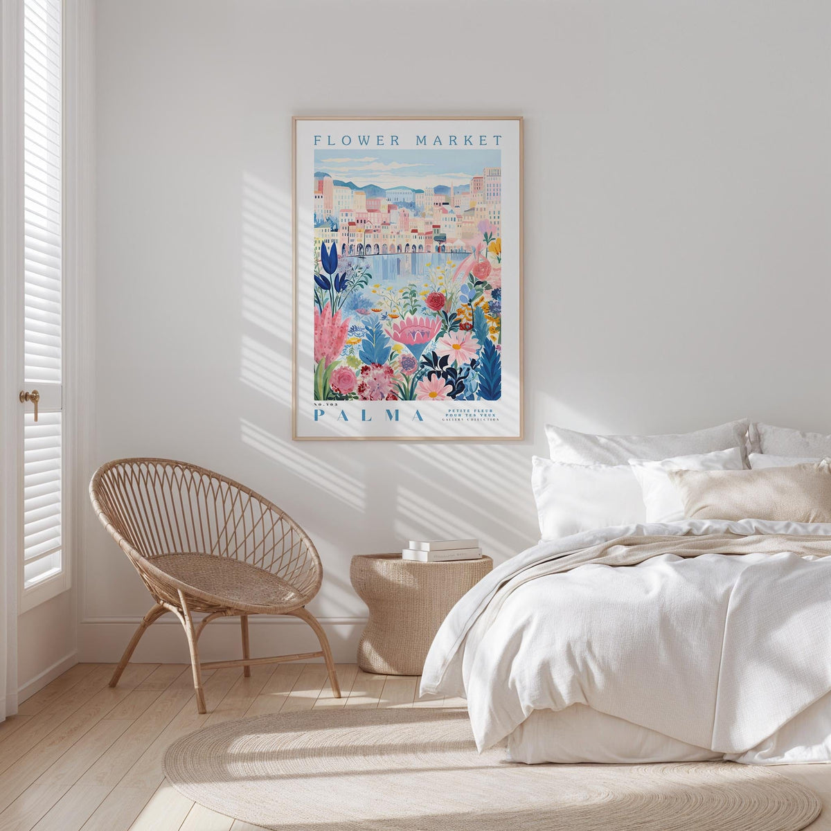 a bedroom with a bed, a woven chair, and a framed poster of a colorful floral scene hanging on the wall.