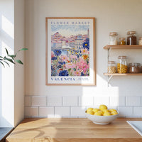 a framed poster of a colorful floral scene hanging on a wall above a wooden countertop with a bowl of lemons.