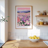 a framed poster of a field of flowers, with the word "Montana" written on it, hanging on a wall above a wooden counter with a bowl of lemons on it.