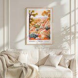 a framed poster of a desert landscape with a tree, hanging on a wall above a white couch with a blanket draped over it.