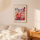 a bedroom scene with a framed poster of a cityscape and a bed with striped pillows.