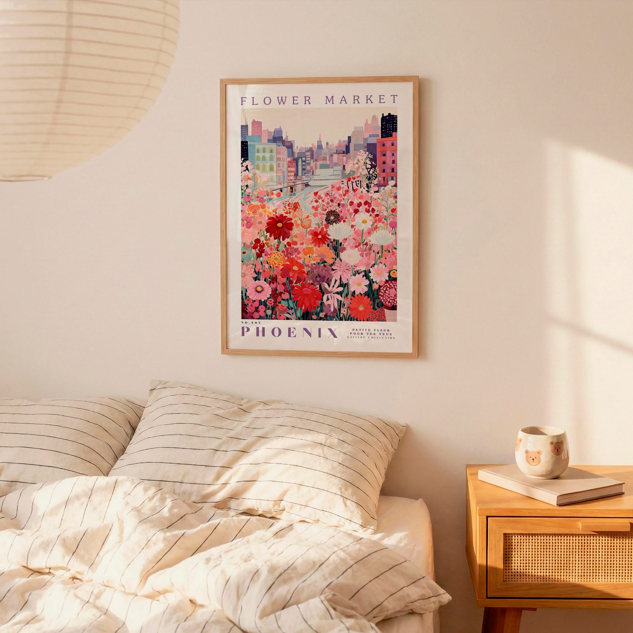 a bedroom scene with a framed poster of a cityscape and a bed with striped pillows.