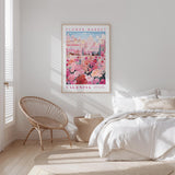 a bedroom with a bed, a woven chair, and a framed poster of a flower market in Valencia hanging on the wall.