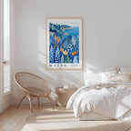 a serene bedroom scene with a large framed poster of a coastal landscape hanging on the wall, a wicker chair, and a bed with white bedding.