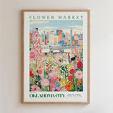 The image is a framed poster depicting a vibrant cityscape with a colorful flower garden in the foreground.