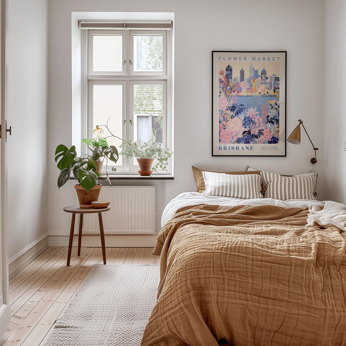 a cozy bedroom with a large bed, a wooden nightstand, and a window with a plant on the sill. The room has a neutral color scheme with a brown blanket and a striped pillow. There is a framed poster of a cityscape on the wall, and a potted plant is placed on the windowsill.