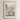 The image is a framed poster depicting a vibrant and colorful garden scene with various flowers and plants.