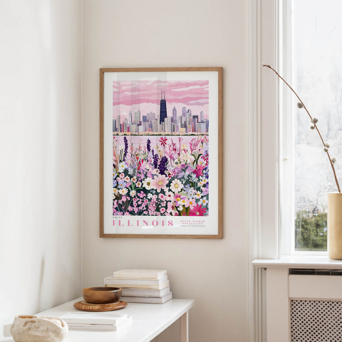 a framed poster of a city skyline with a colorful floral scene below it, hanging on a wall in a room.