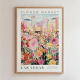 The image is a framed poster depicting a vibrant and colorful flower market in Las Vegas, with a cityscape in the background.