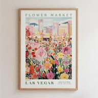 The image is a framed poster depicting a vibrant and colorful flower market in Las Vegas, with a cityscape in the background.