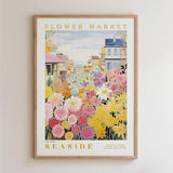 The image is a framed poster depicting a vibrant and colorful flower market scene, with various flowers and buildings in the background.