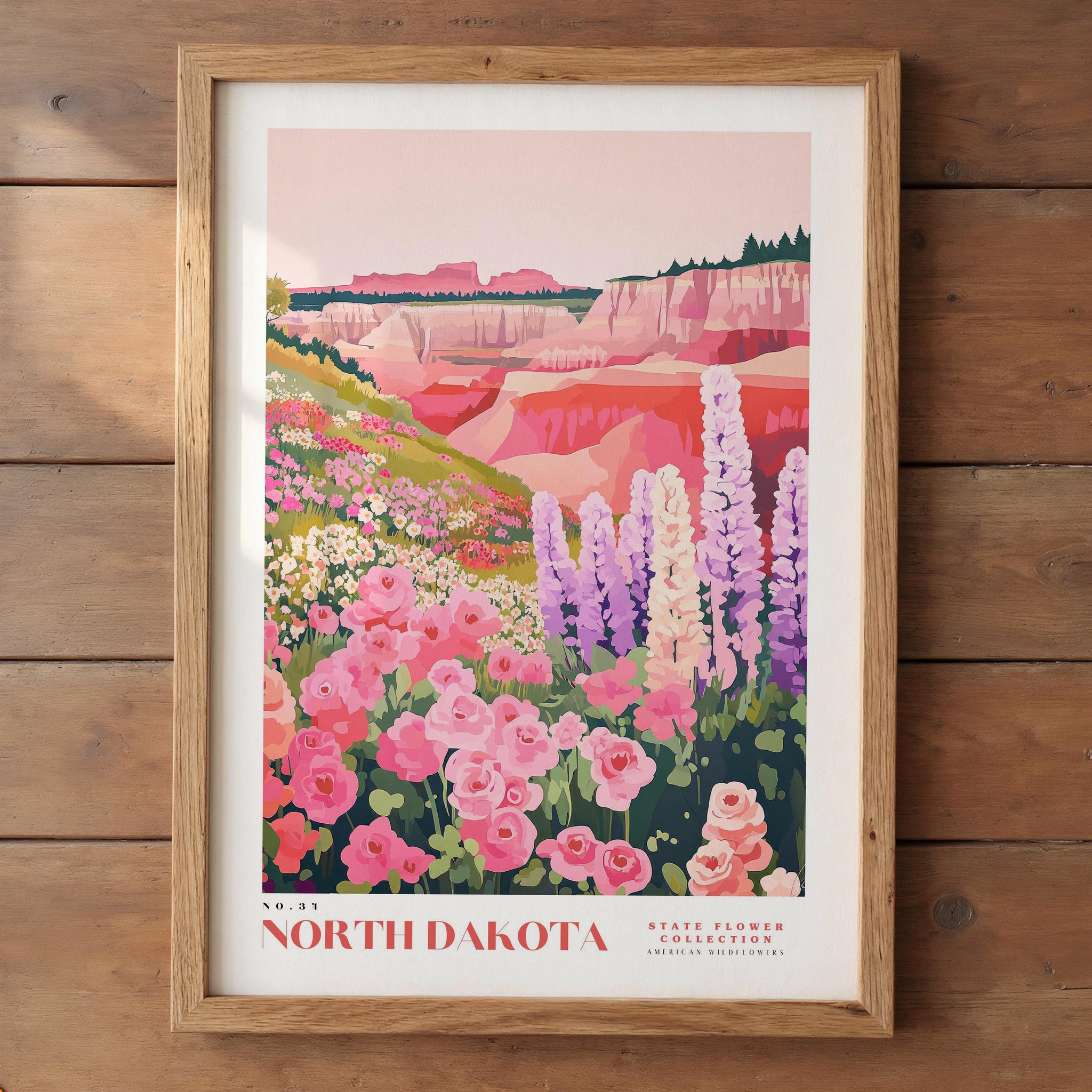 The image is a framed poster depicting a scenic landscape of the North Dakota state flower collection, featuring a vibrant field of pink and white flowers against a backdrop of mountains and cliffs.
