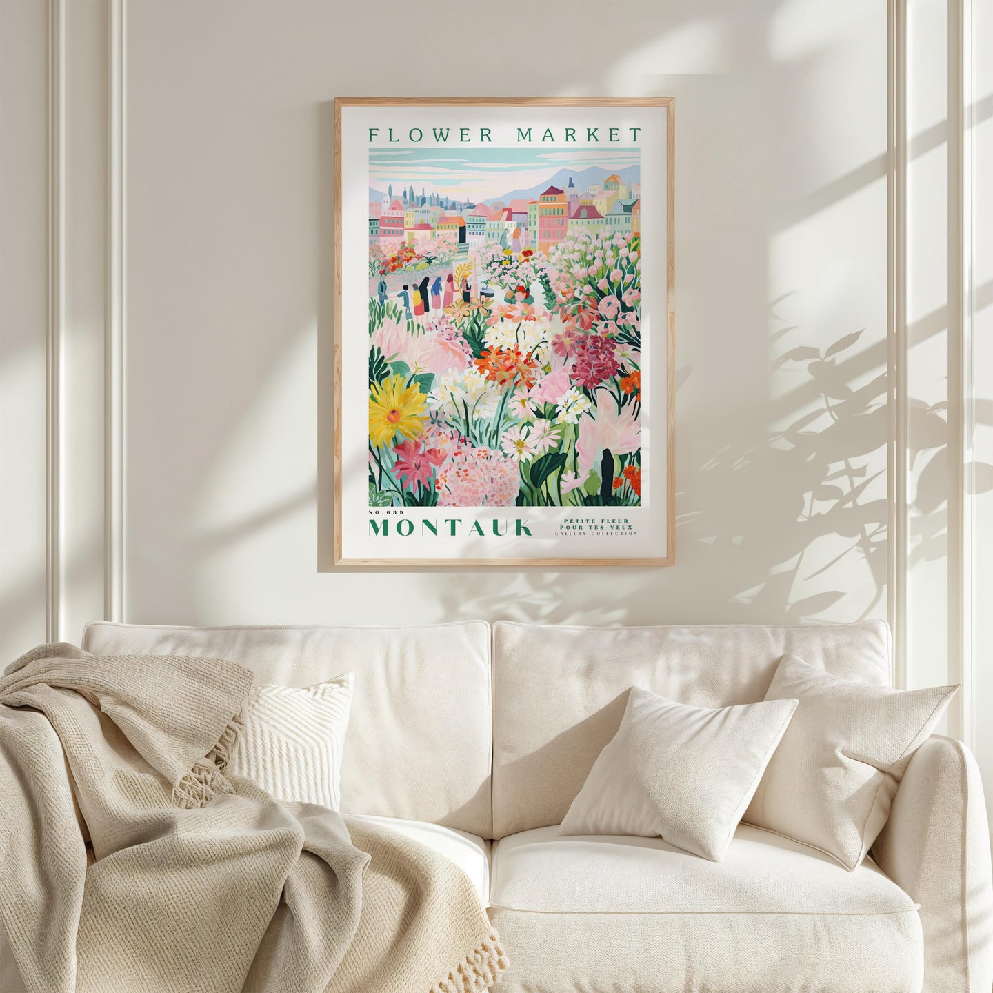 a poster of a flower market hanging on a wall above a white couch with a blanket draped over it.