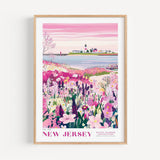 A framed poster depicting a scenic landscape with a lighthouse, a small town, and a field of colorful flowers.