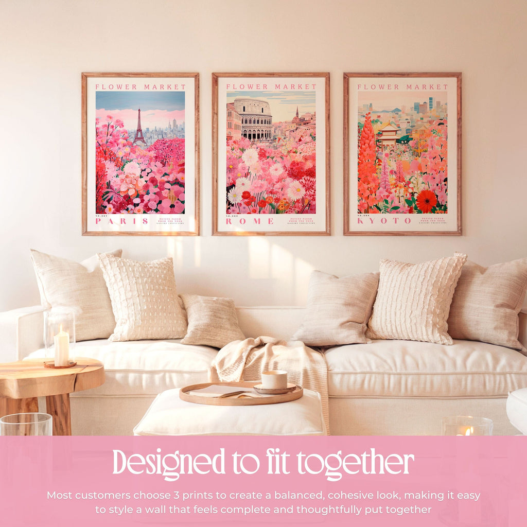 a cozy living room with three framed prints of flower market scenes hanging on the wall. The prints depict Paris, Rome, and Kyoto, creating a harmonious and visually appealing display. The arrangement of the prints and the matching pillows on the couch contribute to a cohesive and stylish atmosphere in the room.