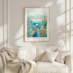 a framed poster of a colorful floral scene hanging on a wall above a white couch with a blanket draped over it.