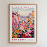 The image is a framed poster depicting a vibrant and colorful flower market in Saint Paul, with a variety of flowers and buildings in the background.