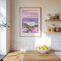 a kitchen counter with a bowl of lemons, a framed picture of a beach scene, and a shelf with jars and bottles.