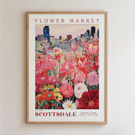 A framed poster depicting a vibrant and colorful flower market in Scottsdale, with a cityscape in the background.
