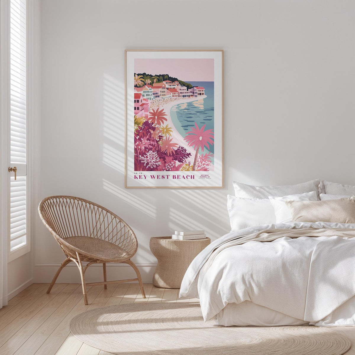 a bedroom with a large poster of a beach scene hanging on the wall, a wicker chair, and a bed with white bedding.