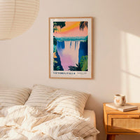 a bedroom scene with a framed poster of Victoria Falls hanging on the wall above a bed with striped pillows.