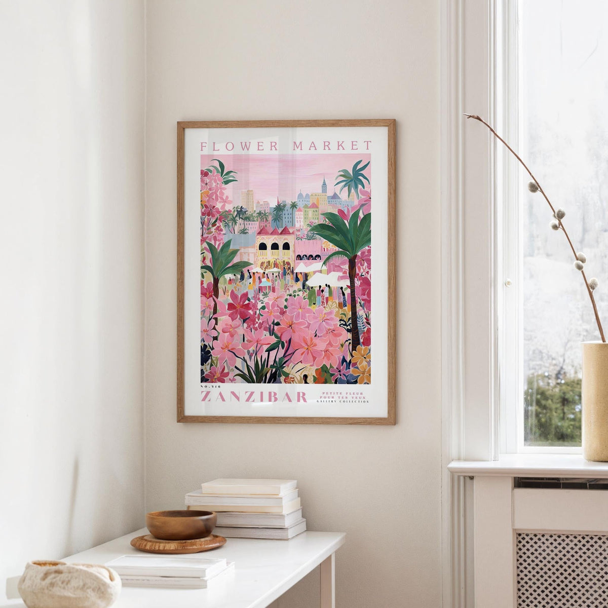 a framed poster of a colorful, tropical flower market in Zanzibar hanging on a wall.