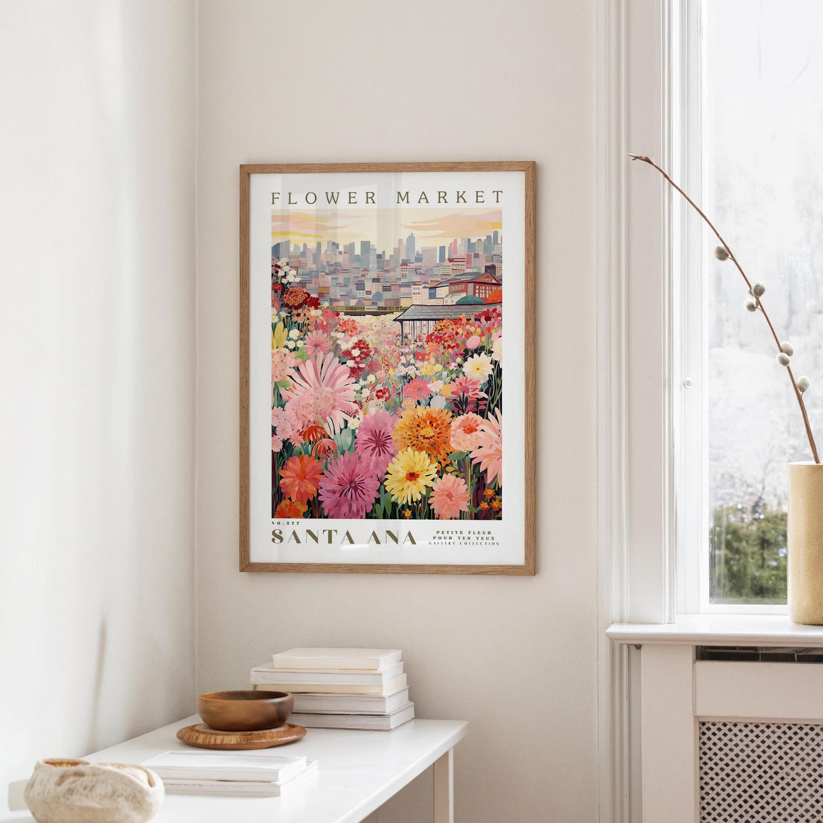 a framed poster of a colorful flower market in Santa Ana, California, hanging on a wall.