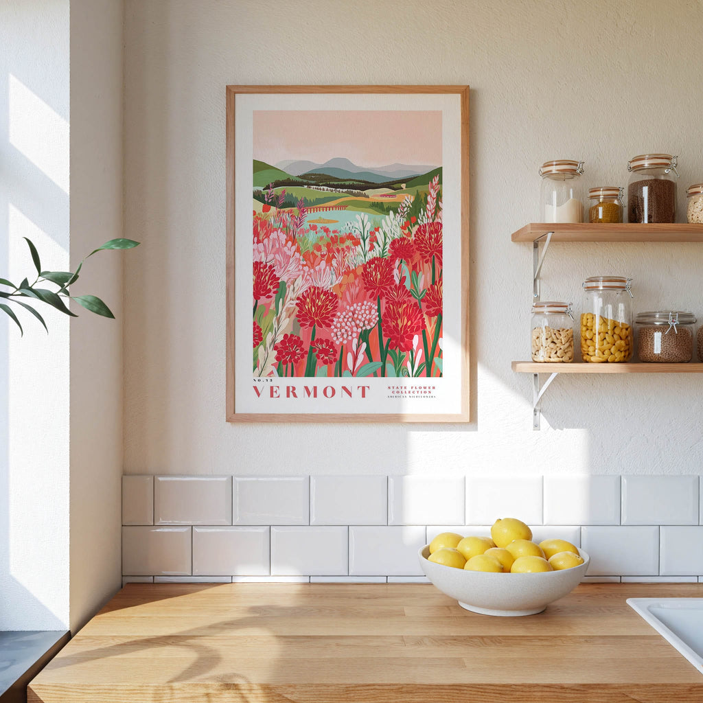 a framed poster of a field of flowers hanging on a wall above a wooden countertop with a bowl of lemons.