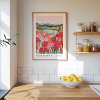 a framed poster of a field of flowers hanging on a wall above a wooden countertop with a bowl of lemons.