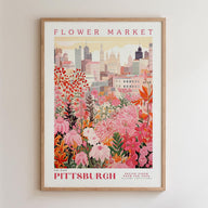 A framed poster depicting a vibrant cityscape with a variety of colorful flowers in the foreground, set against a backdrop of tall buildings.