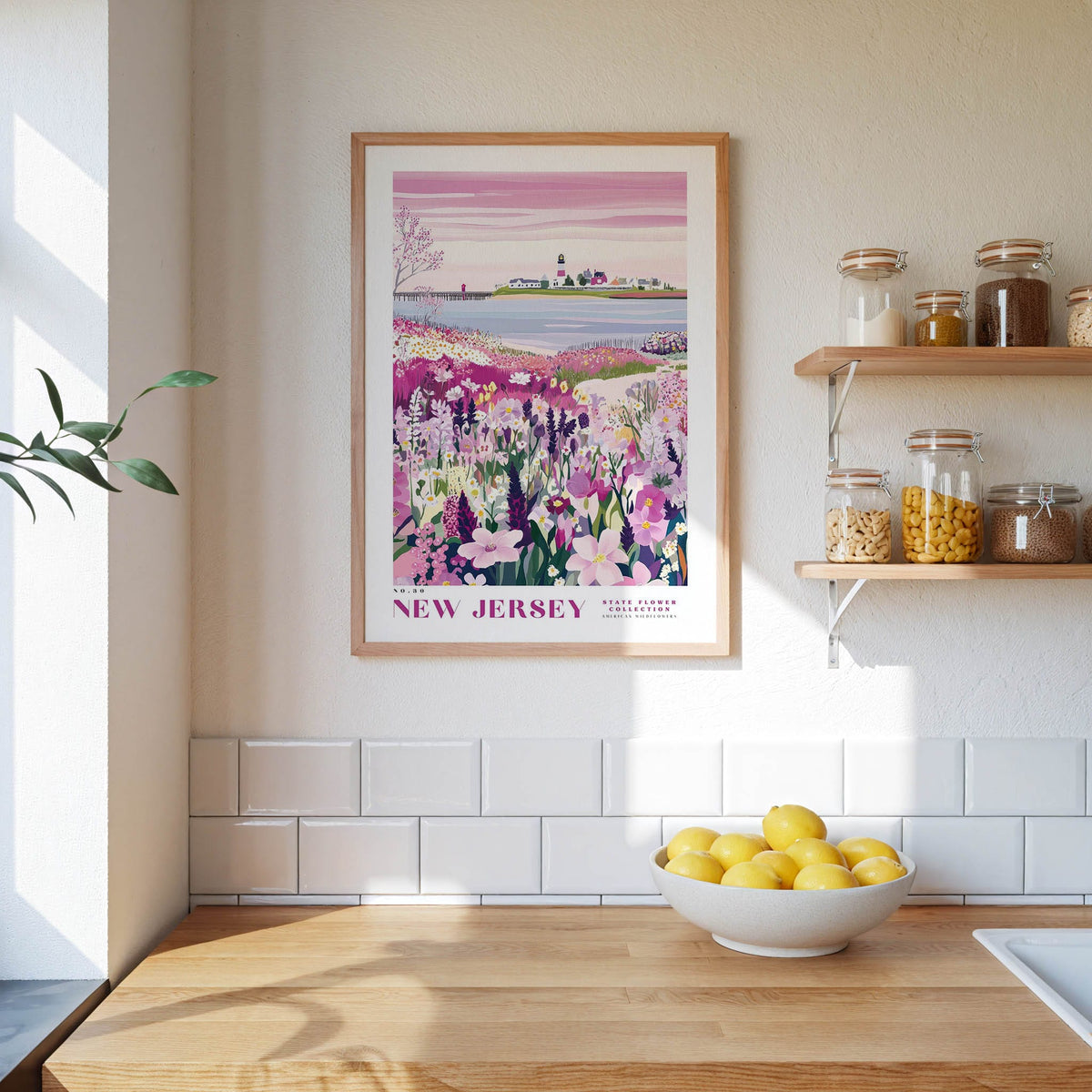 a kitchen scene with a framed poster of a field of flowers hanging on the wall, a wooden counter with a bowl of lemons, and shelves displaying various jars and containers.