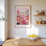 a framed poster of a colorful floral scene hanging on a wall above a wooden countertop with a bowl of lemons.