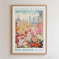 The image is a framed poster depicting a vibrant and colorful flower market in Des Moines, Iowa.