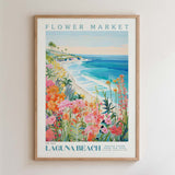 The image is a framed poster depicting a vibrant and colorful scene of a flower market on Laguna Beach, California.