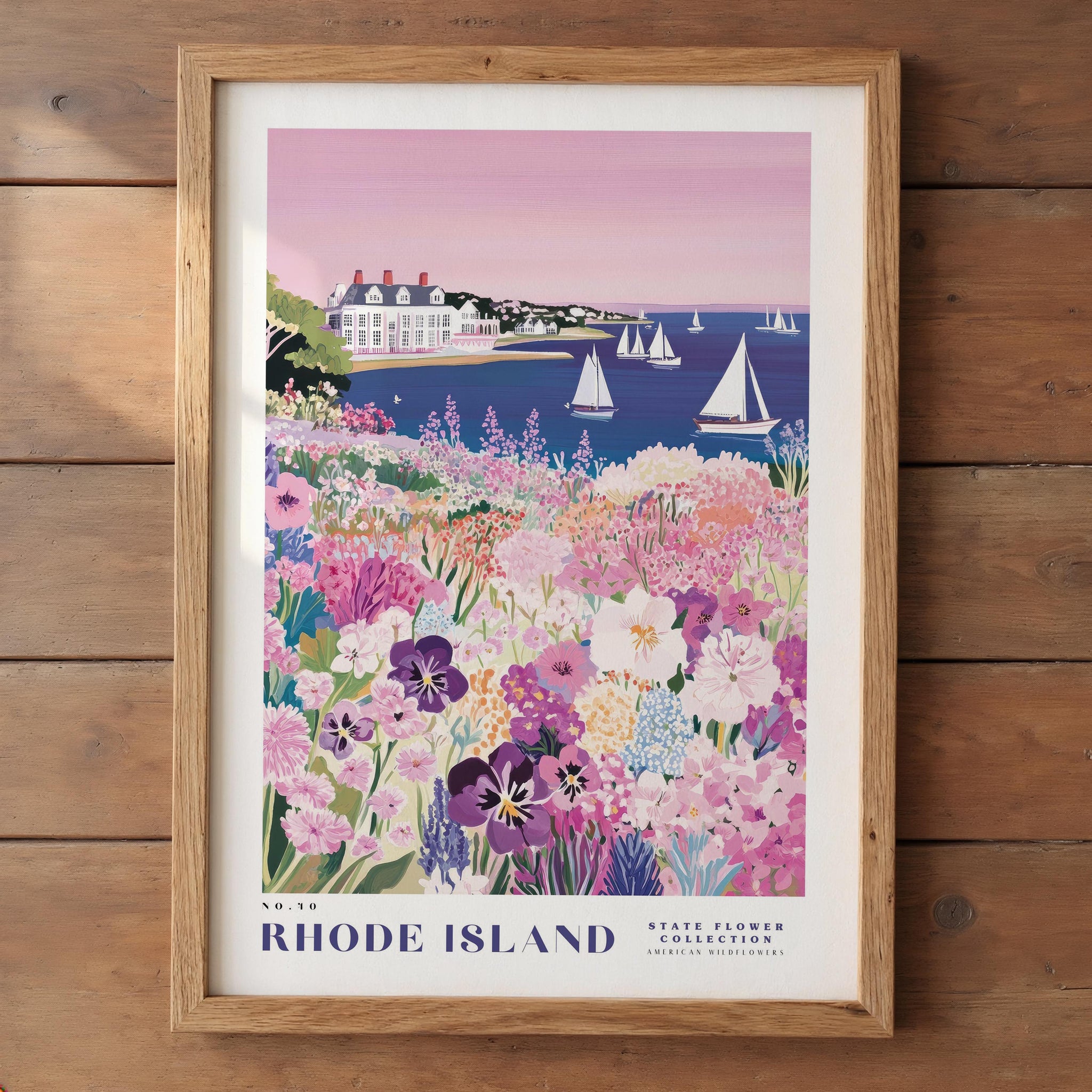 A framed poster depicting a scenic view of Rhode Island, with a colorful landscape featuring a house, flowers, and sailboats on the water.